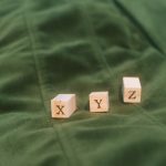 Wooden blocks with letters X, Y, Z on green fabric background.